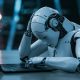 robot frustrated in front of laptop